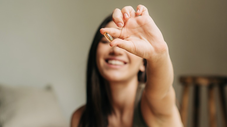 woman holding out capsule 