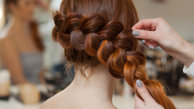 Woman wearing her red hair in a French braid