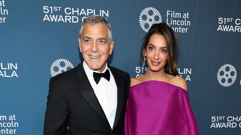 George and Amal Clooney smiling and looking to the side