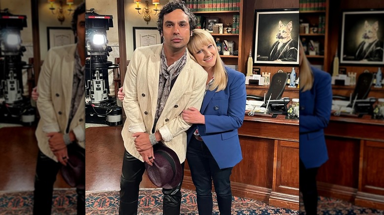 Melissa Rauch linking arms with Kunal Nayyar on the "Night Court" set.