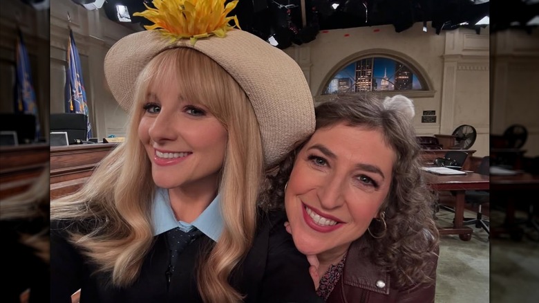 Melissa Rauch wearing a hat and taking a selfie with Mayim Bialik on the "Night Court" set.