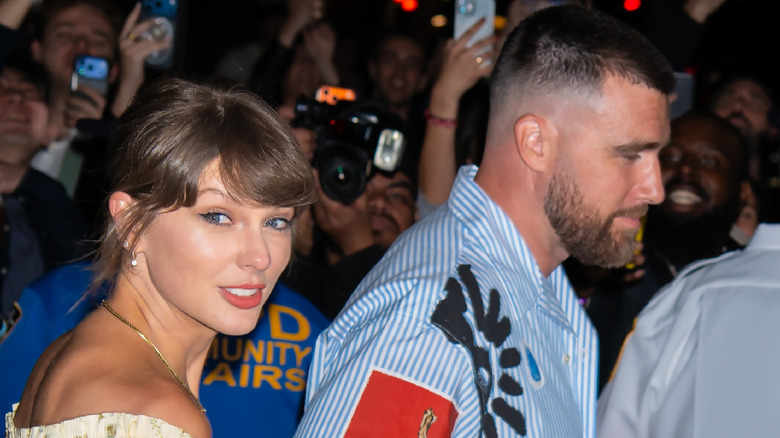 Taylor Swift smiling next to Travis Kelce