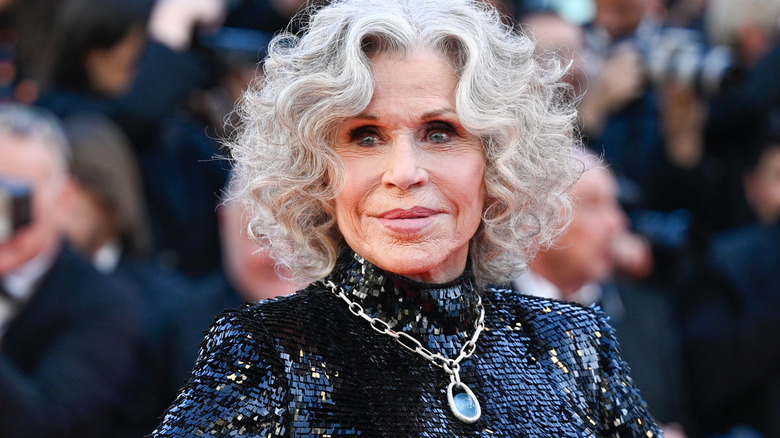 Jane Fonda dressed in black poses for a photo in front of a crowd
