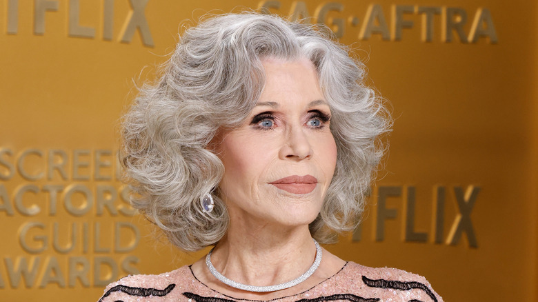 Jane Fonda poses for a photo against a gold backdrop