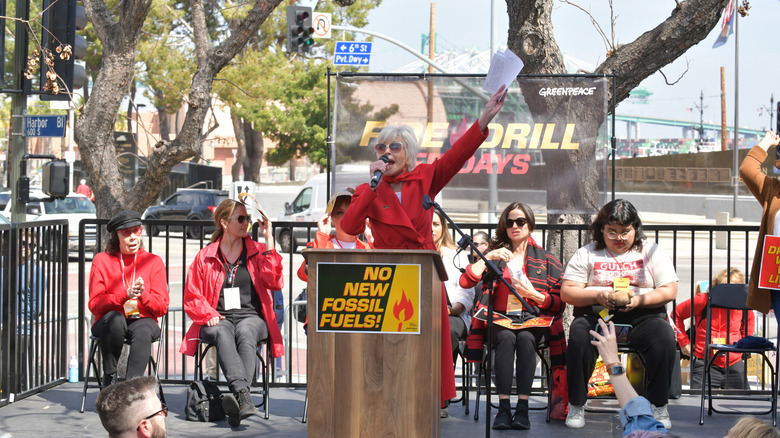 Jane Fonda speaks from a podium for a Greenpeace environmental event