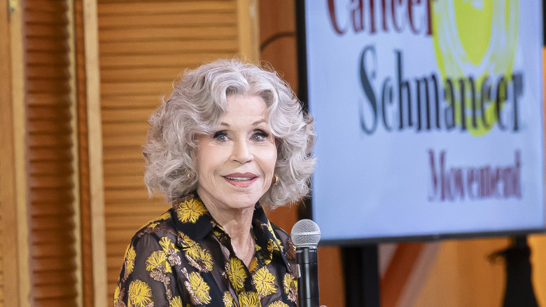 Jane Fonda holds a microphone while speaking at a cancer event
