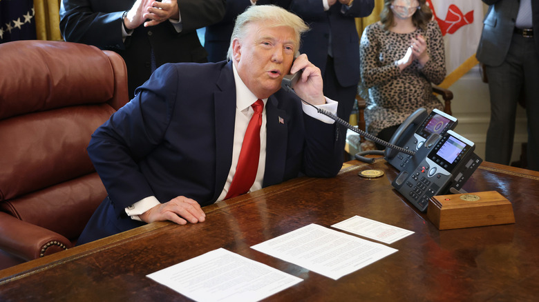 Donald Trump speaking on the phone from behind the Resolute desk