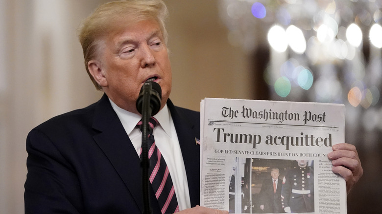 Donald Trump showing a copy of The Washington Post to an audience