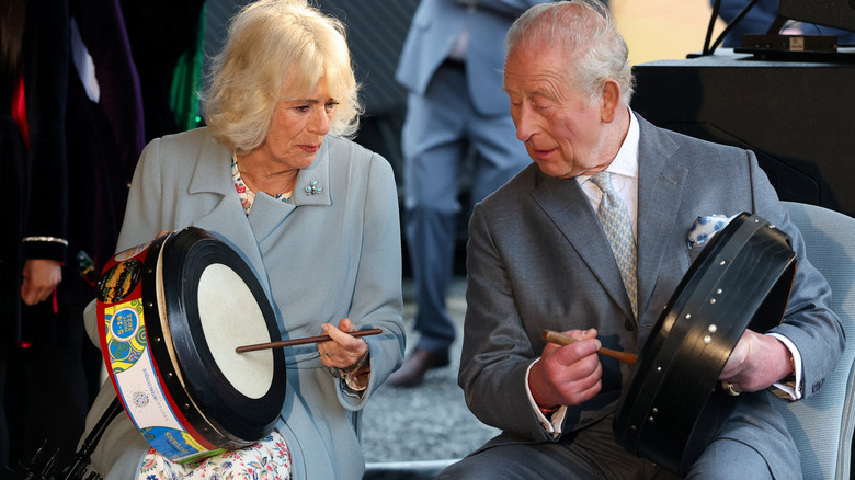 King Charles III and Queen Camilla playing traditional Irish drums