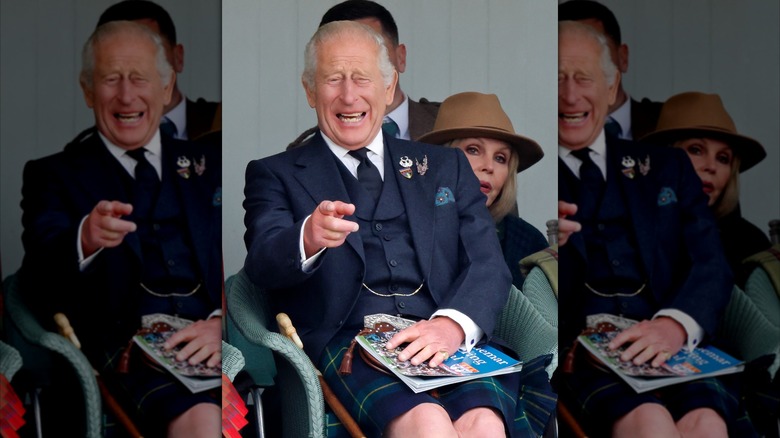 A laughing King Charles III wearing a kilt