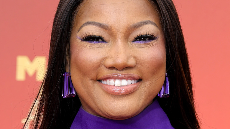 Garcelle Beauvais smiling with purple eyeliner