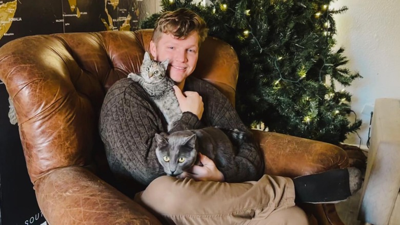 Garrison Brown smiling with cats