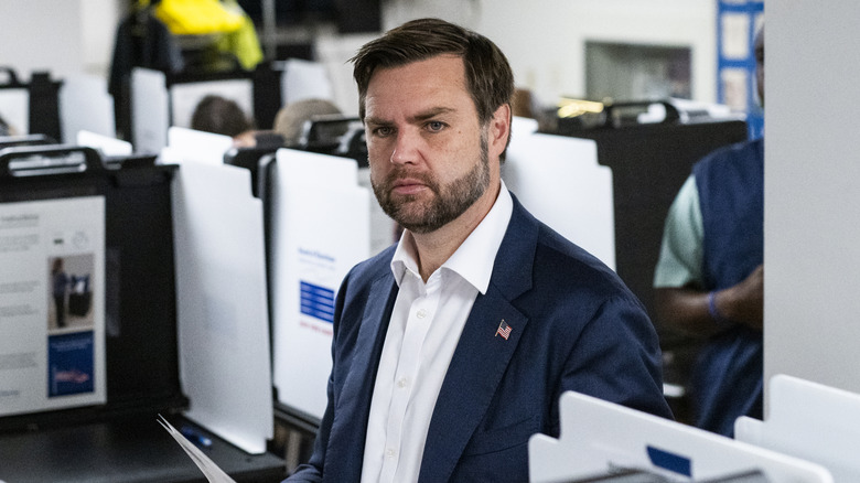 JD Vance holds pieces of paper