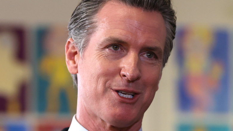 Gavin Newsom with his hands in the air