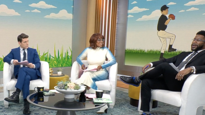 Gayle King holding paper, looking at Nate Burleson with Tony Dokoupil on the left