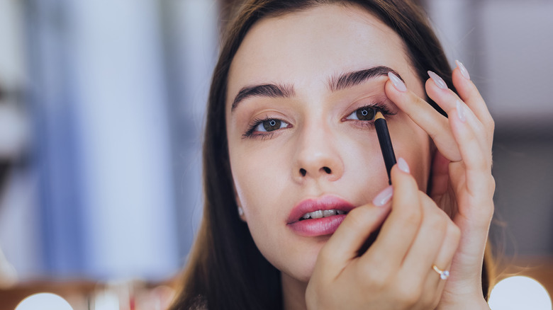 Woman applying eyeliner