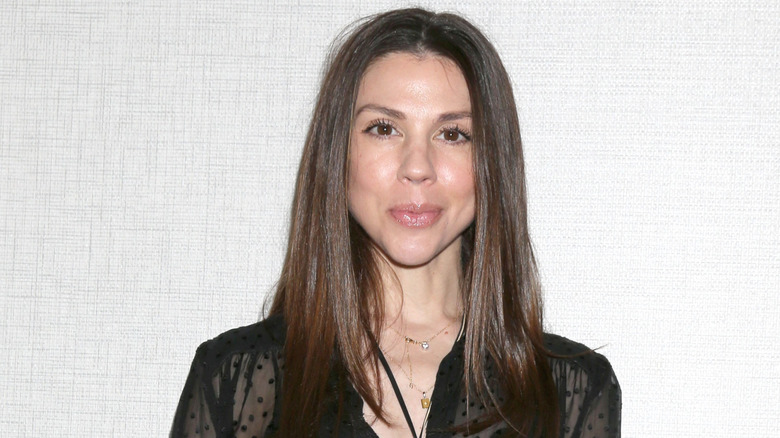 Kate Mansi poses at an event for "General Hospital" fan club with her lips pursed and hair down wearing a black shirt
