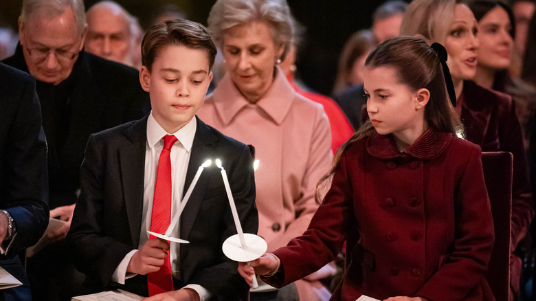 Prince George and Princess Charlotte pass a flame via candles at Christmas