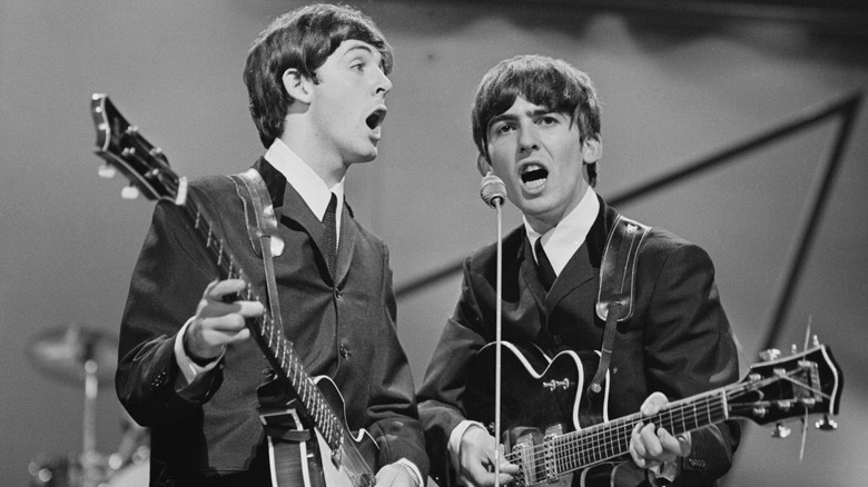 Black-and-white photo of Paul McCartney and George Harrison performing onstage