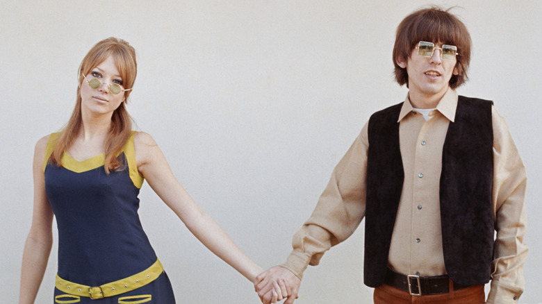 Pattie Boyd and George Harrison holding hands far apart