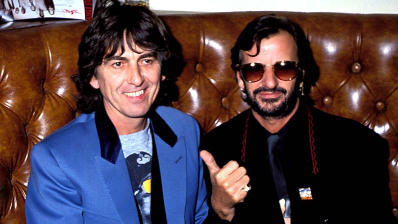 Ringo Starr pointing at George Harrison with his thumb