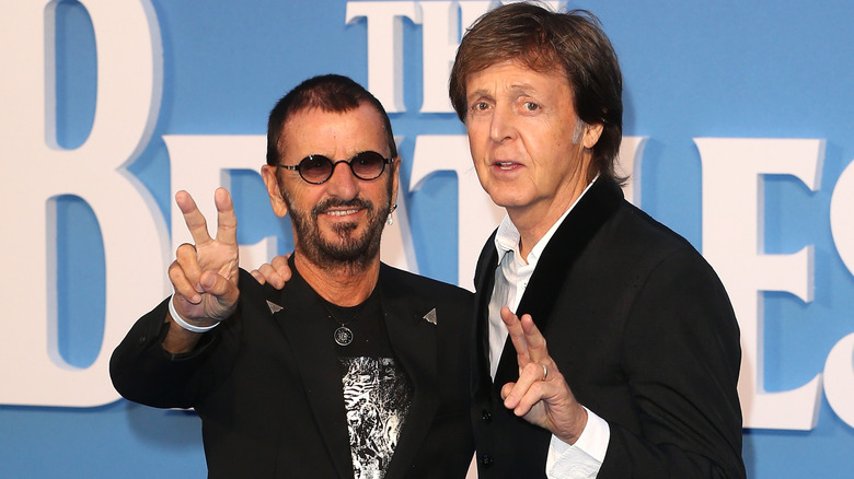 Ringo Starr and Paul McCartney giving peace signs
