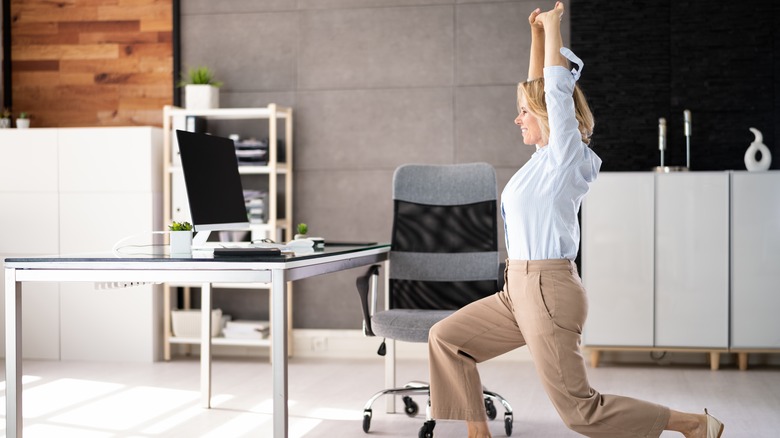 woman doing glute exercises at her desk 