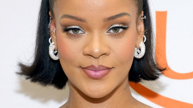 Rihanna wearing diamond earrings and smiling