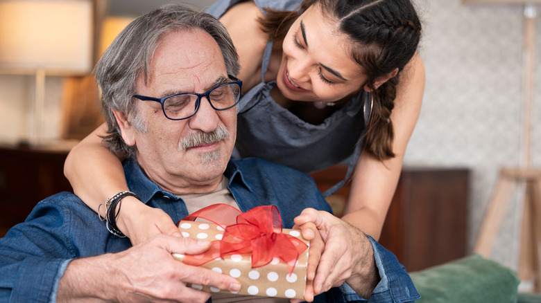 woman giving present to older man