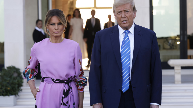 Melania Trump and Donald Trump standing next to each other, unsmiling