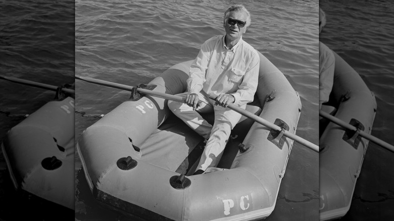 Buddy Emsen rowing in a dinghy with sunglasses on