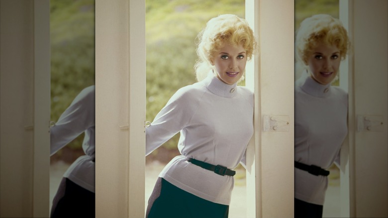Donna Douglas in a white turtleneck with a belt