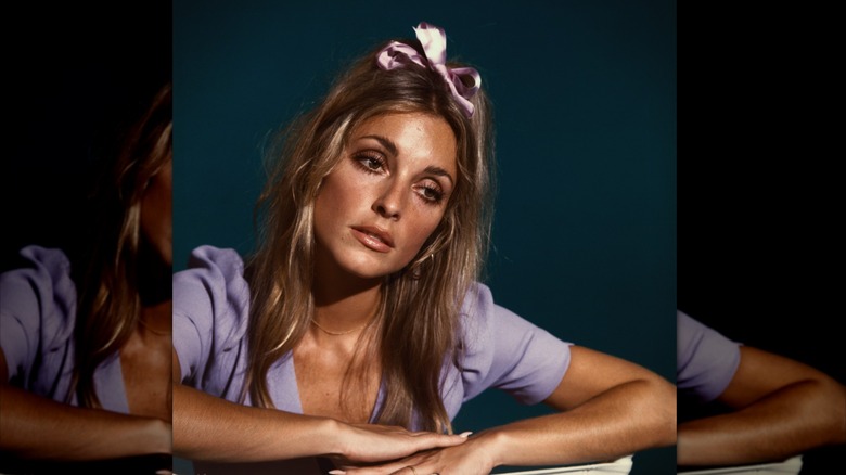 Sharon Tate wearing a bow in her hair and a purple top