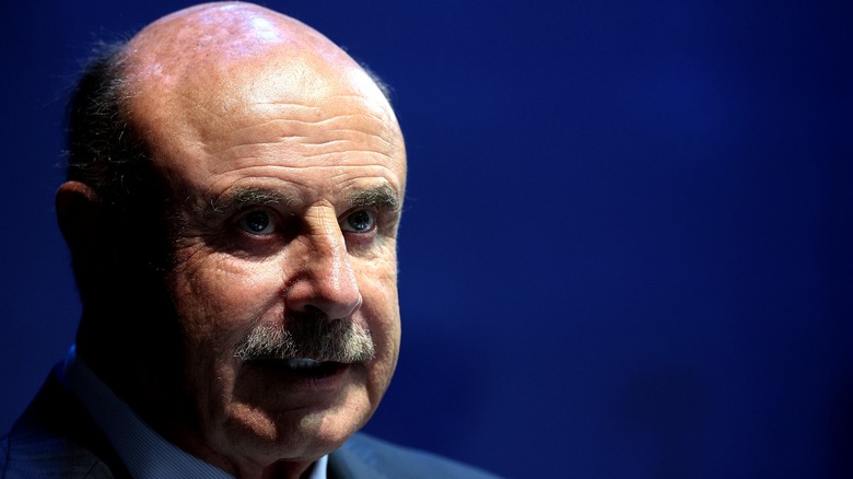 Dr. Phil blue background looking serious