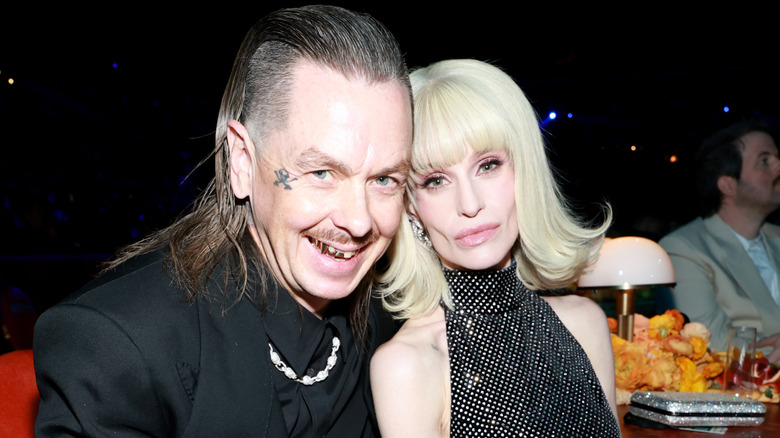 image of Sid Wilson with a wide smile and Kelly Osbourne with a small smile beside him at an event