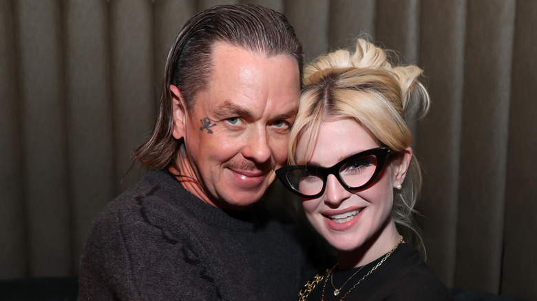 Sid Wilson and Kelly Osbourne hugging each other and smiling for the camera