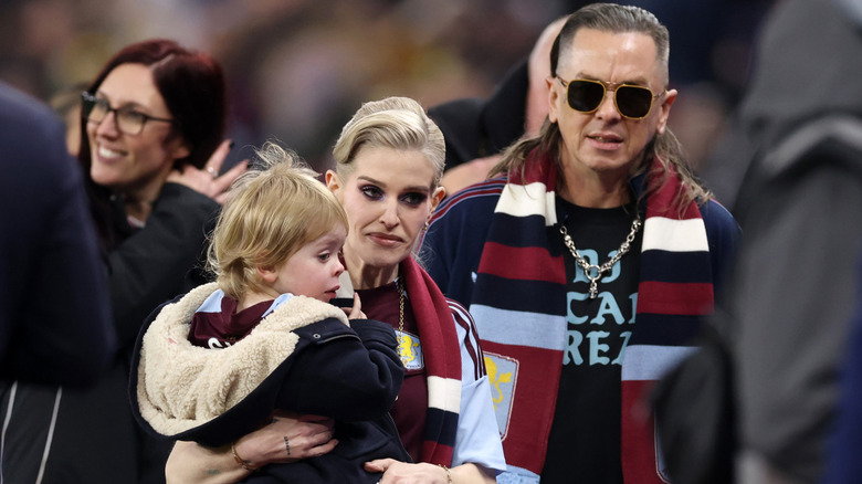 image of Kelly Osbourne carrying her son beside her husband Sid Wilson