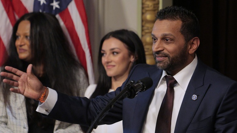 Kash Patel speaks after being sworn in, with girlfriend Alexis Wilkins looking on behind him. Washington, DC (2025)