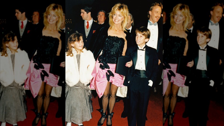Kate Hudson, Goldie Hawn, and Oliver Hudson walk hand-in-hand