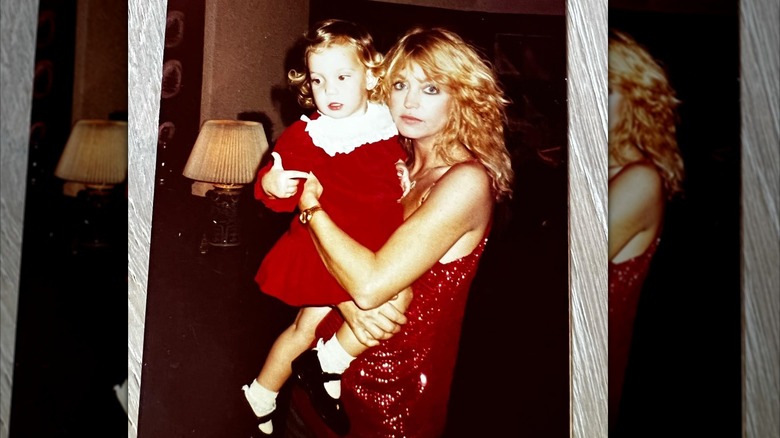 Goldie Hawn holds a young Kate Hudson in matching red dresses
