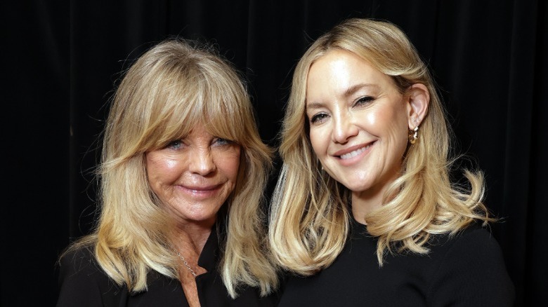 Goldie Hawn and Kate Hudson smiling in matching black tops