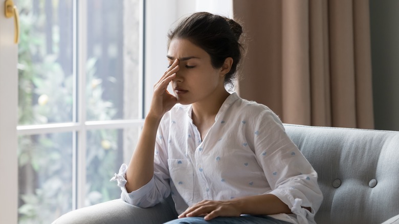 Woman looking stressed on couch