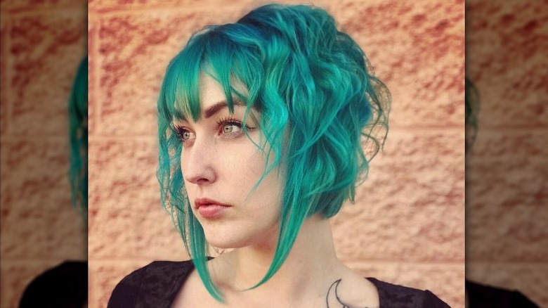 Person with teal-colored disconnected bob