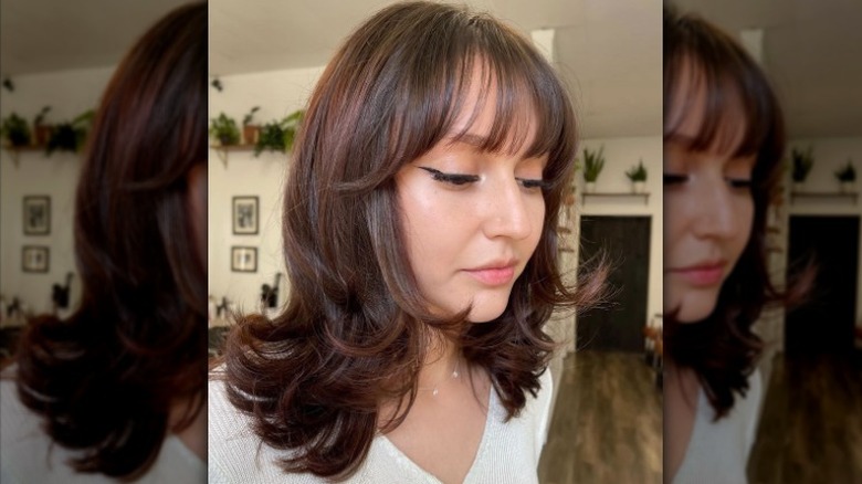 Person with wispy bangs and layered hair