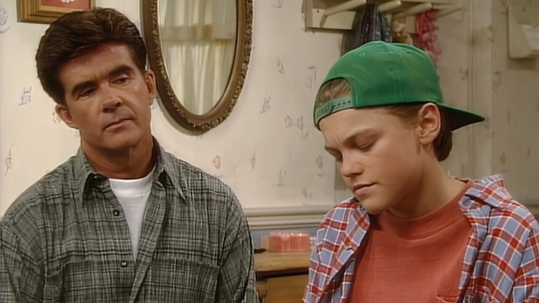 Leonardo DiCaprio wearing a backward baseball hat and looking down as Alan Thicke looks at him on "Growing Pains."
