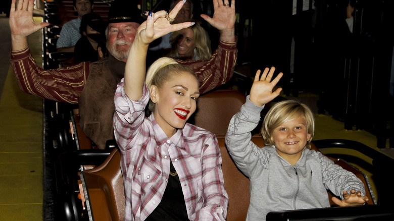 Gwen Stefani and Zuma Rossdale waving on roller coaster