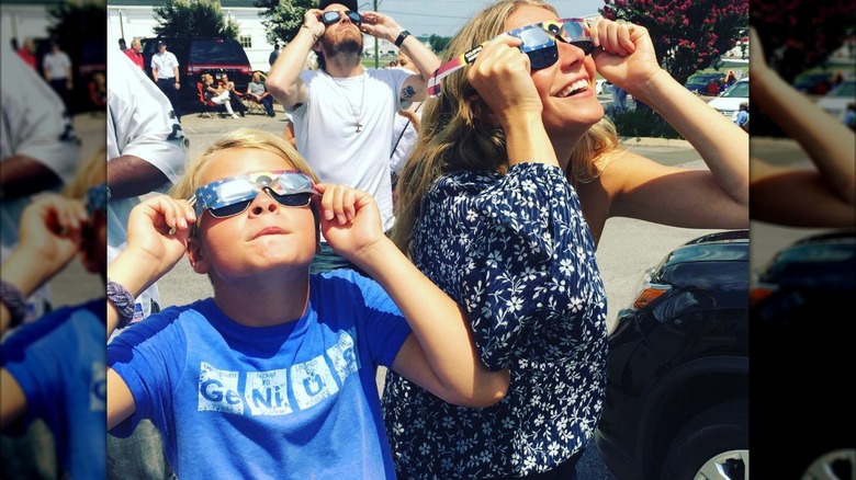 Moses Martin and Gwyneth Paltrow looking at the sky with sunglasses on
