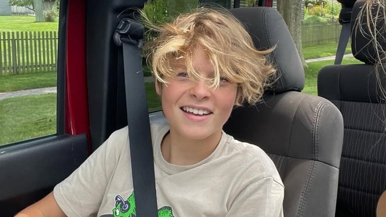 Moses Martin smiling in the passenger seat of a car