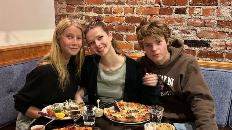 Gwyneth Paltrow, Apple Martin, and Moses Martin smiling at a restaurant