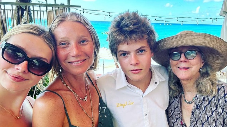 Gwyneth Paltrow, Moses Martin, and Apple Martin smiling with a family member on the beach